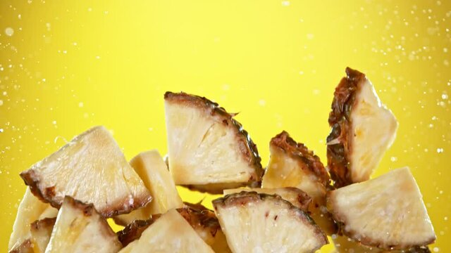 Super slow motion of sliced pineapple with water splash flying in the air. Filmed on high speed cinema camera, 1000 fps.
