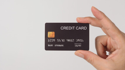 Hand is holding black credit card isolated on white background.