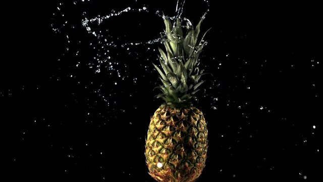 Super slow motion fresh rotating pineapple with water droplets. On a black background. Filmed on a high-speed camera at 1000 fps.