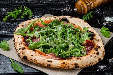 neapolitan homemade pizza with prosciutto and arugula from the oven