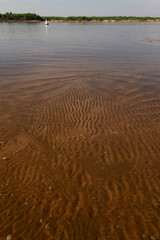natural background with a river lagoon, a sandy shore and a horizon