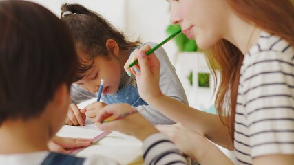 Asian boy and girl sit at desk study online on laptop, smart little kids handwrite in notebook learning using internet lessons on quarantine, homeschooling concept.

