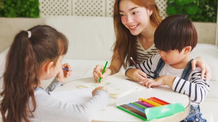 Naklejka premium Asian boy and girl sit at desk study online on laptop, smart little kids handwrite in notebook learning using internet lessons on quarantine, homeschooling concept. 