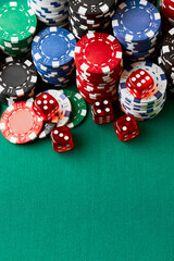 Pile of Casino pocker gambling chips and dices on green table