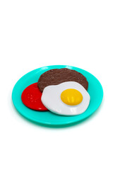 Isolated photo of a toy breakfast with eggs cutlet and tomato