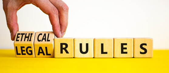 Ethical or legal rules symbol. Businessman turns wooden cubes and changes words 'ethical rules' to 'legal rules' on a beautiful white background. Business, ethical or legal rules concept. Copy space.