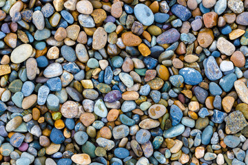 These are wet river pebbles and small round pebbles. Solid background. Top view. Building material or decoration. Wallpaper back.