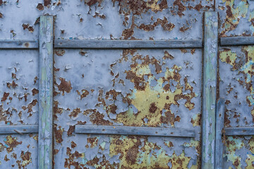 The old wall of the barn is sheathed with iron. There are wooden frames outside. The blue-gray...