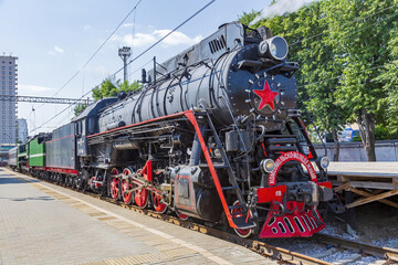 Fototapeta na wymiar Black retro steam locomotive on the railway platform of the Rizhsky station. Moscow, Russia