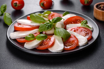 Italian caprese salad with sliced tomatoes, mozzarella cheese, basil, olive oil