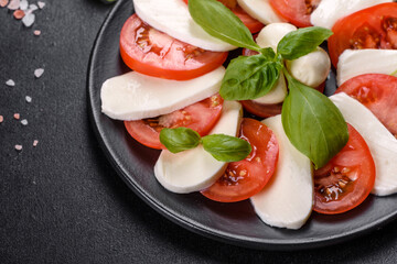 Italian caprese salad with sliced tomatoes, mozzarella cheese, basil, olive oil