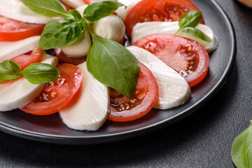 Italian caprese salad with sliced tomatoes, mozzarella cheese, basil, olive oil