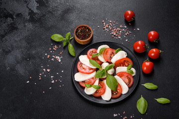 Italian caprese salad with sliced tomatoes, mozzarella cheese, basil, olive oil