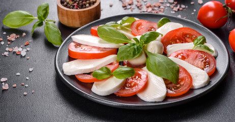 Italian caprese salad with sliced tomatoes, mozzarella cheese, basil, olive oil