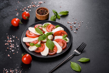 Italian caprese salad with sliced tomatoes, mozzarella cheese, basil, olive oil