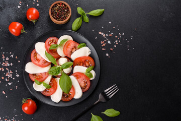 Italian caprese salad with sliced tomatoes, mozzarella cheese, basil, olive oil