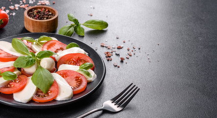 Italian caprese salad with sliced tomatoes, mozzarella cheese, basil, olive oil