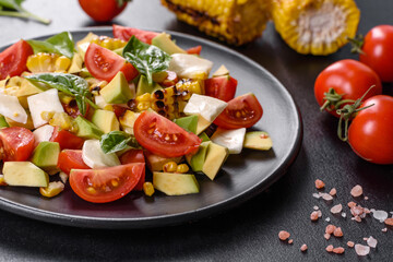 Delicious fresh salad with tomatoes, avocado, cheese and grilled corn with olive oil