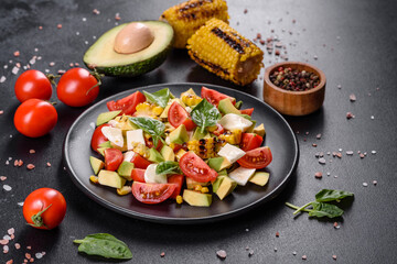 Delicious fresh salad with tomatoes, avocado, cheese and grilled corn with olive oil