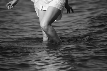 Slim female legs in water in black and white