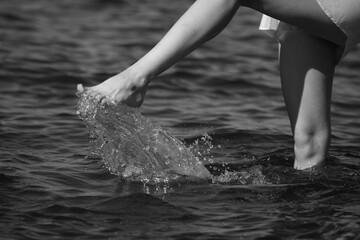 Slim female legs in water in black and white