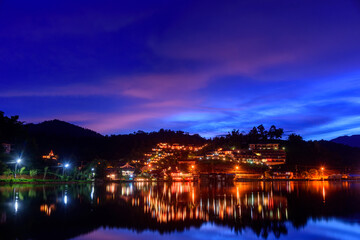 Fototapeta na wymiar Beautiful colorful twilight sky and reflecting water at Ban Rak Thai the village is surrounded by mountain in Mae Hong Son, Thailand.