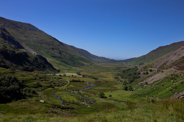 Fototapeta na wymiar Nant Ffrancon Valley and pass with Afon Ogwen winding through it and the A5 road on the right hand side. Part of Snowdonia National Park in North Wales
