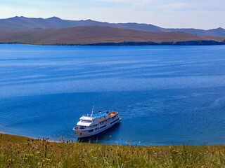 Ship is docked on the wild shore of lake Baikal.