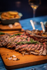 freshly grilled Tomahawk steaks on wooden cutting board and wine