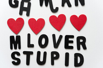 loosely arranged black chalk letters with affectionate message lover stupid and hand painted red...