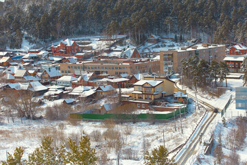 Russian Village in winter. Mountain view of the village and the village school building