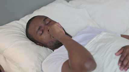 Fototapeta na wymiar Young African Man with Cough Laying in Bed 