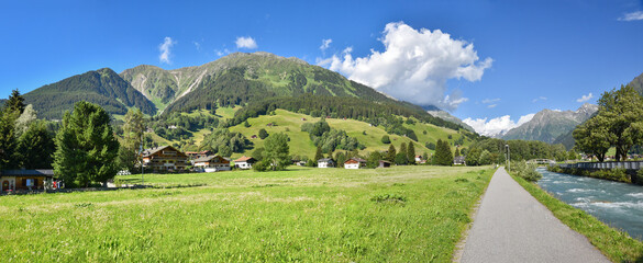 Fototapeta premium Walkway beside Landquart river, view to Madrisa mountain. Tourist resort Klosters switzerland