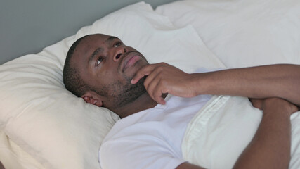 Pensive Young African Man Laying in Bed Thinking 