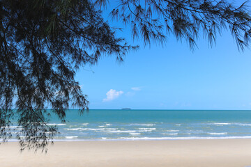 Beautiful natural scene of tropical summer sand beach with blue sea and cloudy sky, ocean waves crashing on beach island