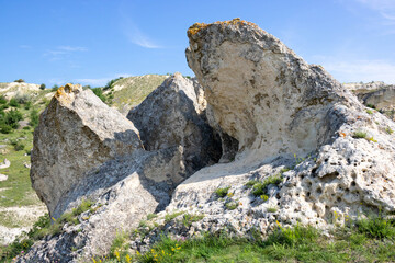 Stone rocks, the texture of a mountain cliff and a beautiful blue sky in the summer season. Traveling on foot