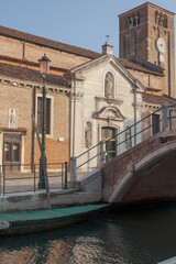 Fototapeta na wymiar Venezia. Facciata della chiesa di San Nicolò dei Mendicoli a Dorsoduro, con ponte e campanile.