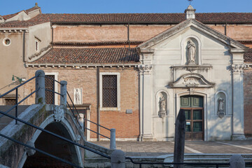 Fototapeta na wymiar Venezia. Facciata della chiesa di San Nicolò dei Mendicoli a Dorsoduro, con ponte e campanile.