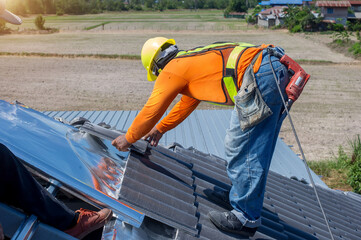 Construction worker install new roof,Roofing tools,Electric drill used on new roofs with Metal Sheet.