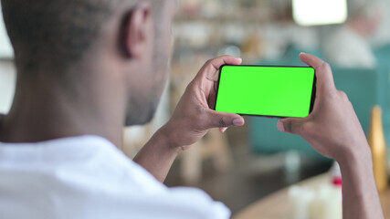 Young African Man Watching Smartphone with Green Chroma Screen 