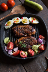 Chicken steak and vegetable saute in a pan with use of selective focus. Top view. 