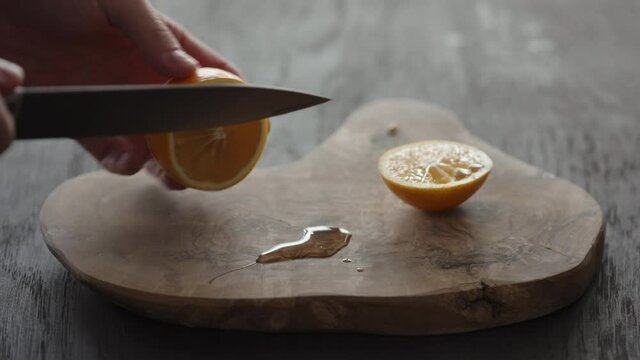 Man cutting sweet lemon on olive wood board