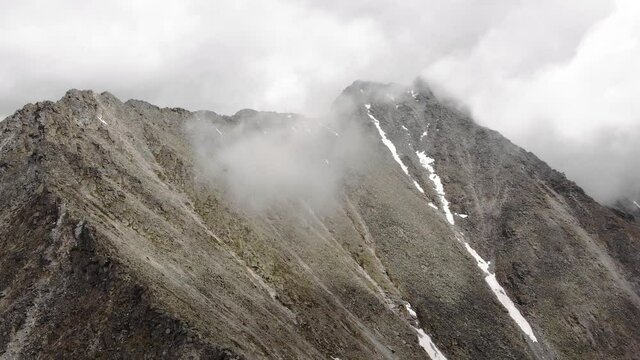 Aerial view of Misty, Fog, low clouds are moving along the slopes of the mountains. Stony slopes, rocks