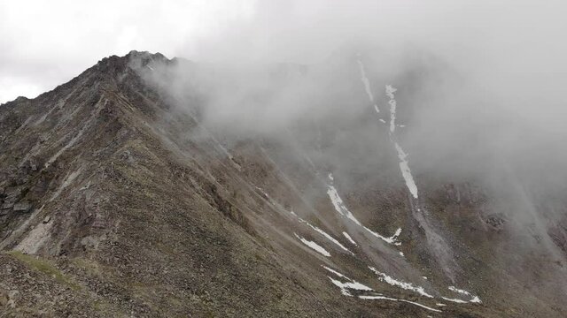 Aerial view of Misty, Fog, low clouds are moving along the slopes of the mountains. Stony slopes, rocks