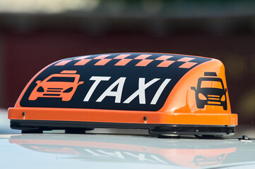 an orange taxi sign stands on the roof of the car