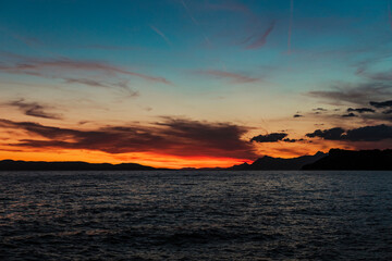 Spectacular sunset view in warm red, orange and purple tones. Beautiful colourful landscape scenery in tucepi, Croatia