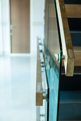 Selective focus to wooden railings mounted to glass in modern building.