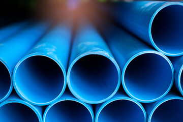 Close up to blue plastic pipe background, PVC pipes stacked in warehouse,  PVC water pipes used for...