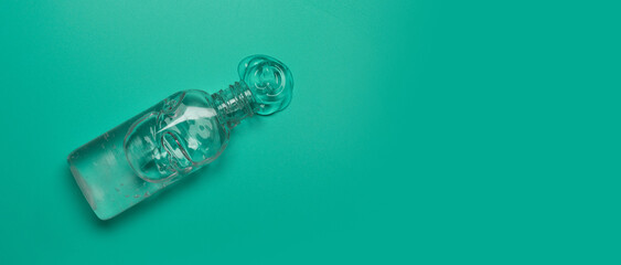 Hands disinfection. Alcohol hand sanitizer gel bottles for hand hygiene corona virus protection on a green background. Top view, copy space