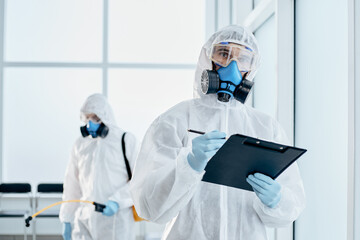 professional disinfector taking notes on the clipboard.